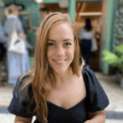 Erica Crowley smiling at the camera against a city background.